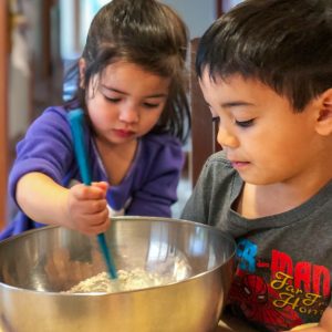 A girl and a boy mixing batter.